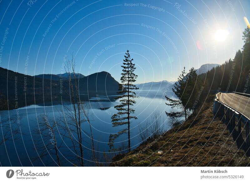 View of Oppstrynsvatnet lake in Norway in the morning hours. Snow covered mountains mountain lake Scandinavia sunshine early mist reflection mountain range