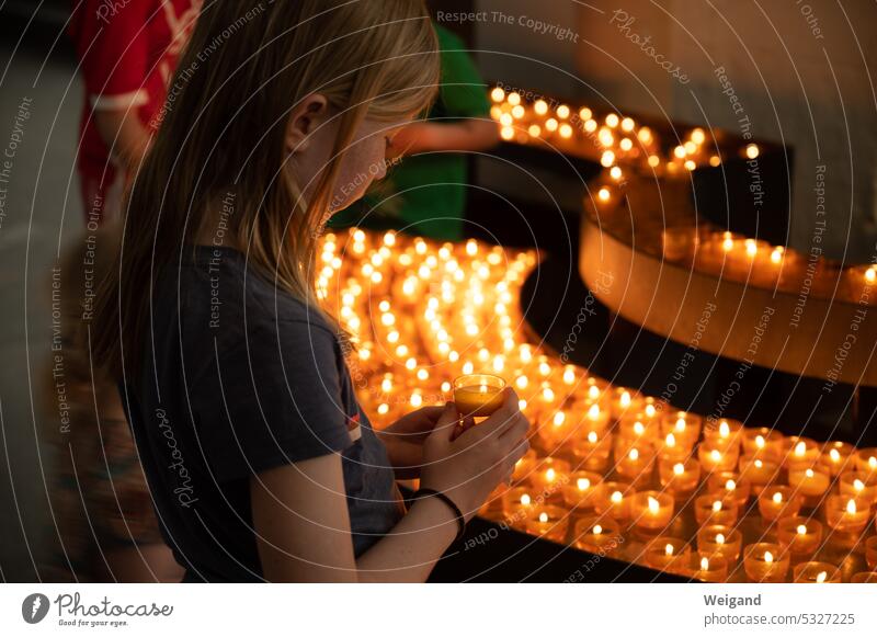 Girl lights a candle in a church shoulder stand Church Belief Infancy Hope Spirituality Family Light Advent pray Prayer Catholic Church service