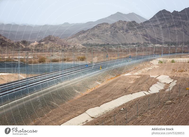 Dual gauge railway tracks with power lines mountain railroad development landscape hill nature highland dry picturesque scenic passage scenery countryside