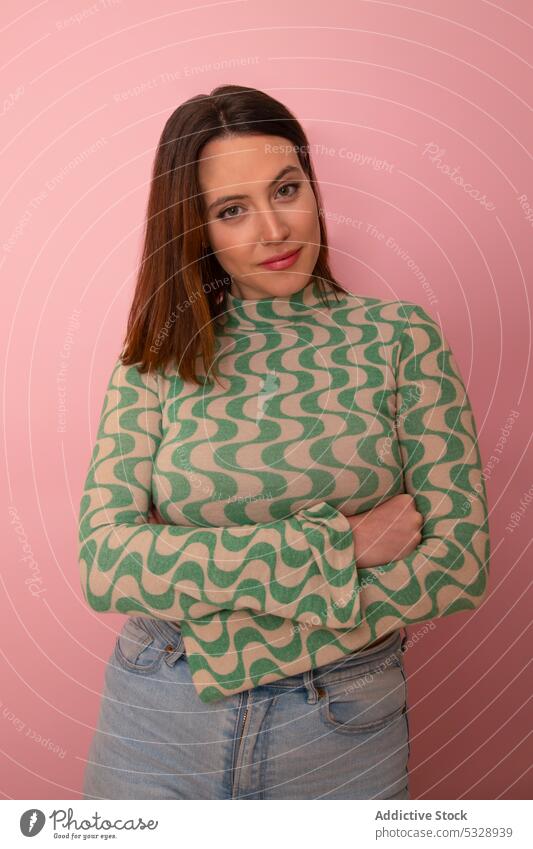 Confident woman with crossed arms against pink background style trendy model appearance arms crossed portrait confident fashion charming individuality denim