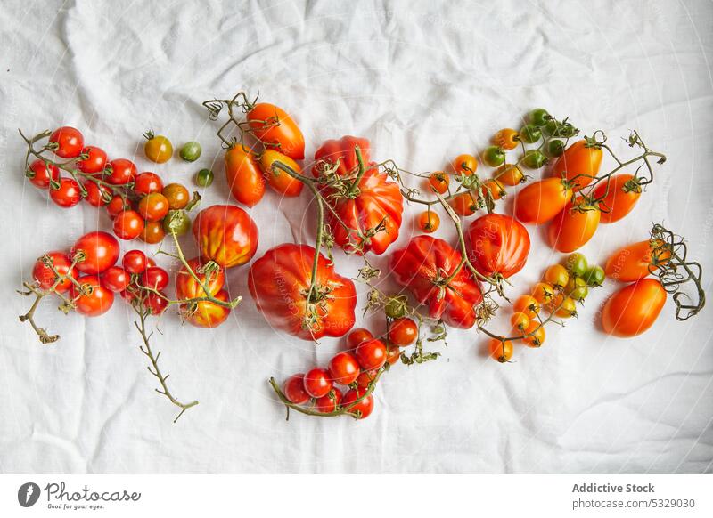 Fresh ripe beef tomatoes on white clothing red fresh raw leaf branch vegetable fabric stem various healthy food natural delicious tasty rough vitamin harvest