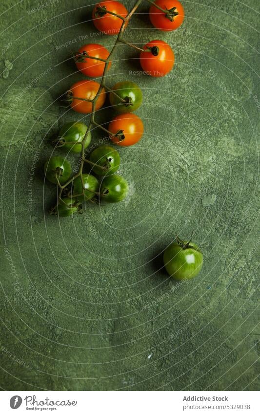 Assorted fresh cherry tomatoes on green surface unripe bunch raw natural organic vegetable harvest food healthy tasty ingredient vitamin agriculture product