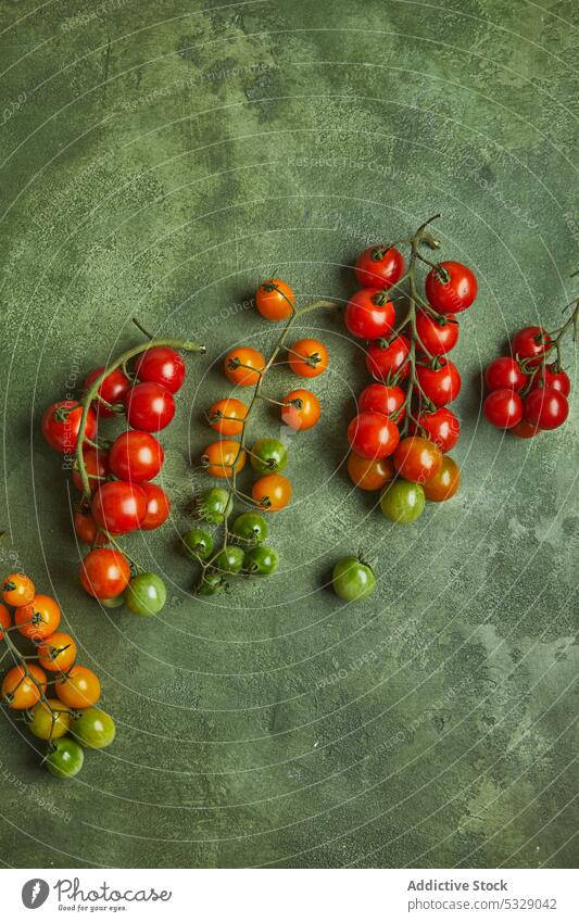 Assorted fresh cherry tomatoes on green surface unripe bunch raw natural organic vegetable harvest food healthy tasty ingredient vitamin agriculture product