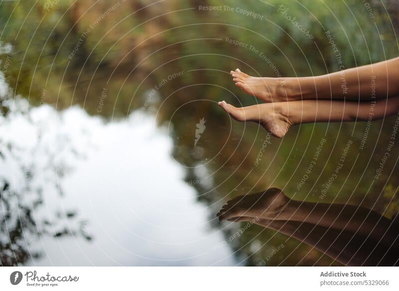 Barefoot legs of unrecognizable woman above lake nature barefoot traveler rest water shore pond female relax calm edge tourism trip harmony tranquil journey