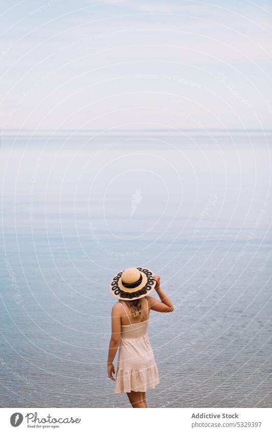 Woman in sunhat admiring seascape woman tourist admire ocean shore relax chill cloudy female model travel trip journey explore summer vacation weekend nature