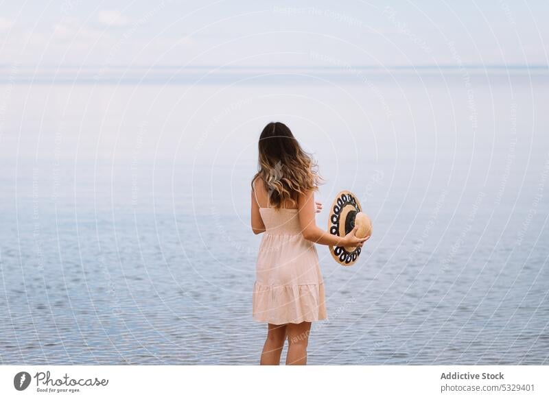 Woman in sunhat admiring seascape woman tourist admire ocean shore relax chill cloudy female model travel trip journey explore summer vacation weekend nature