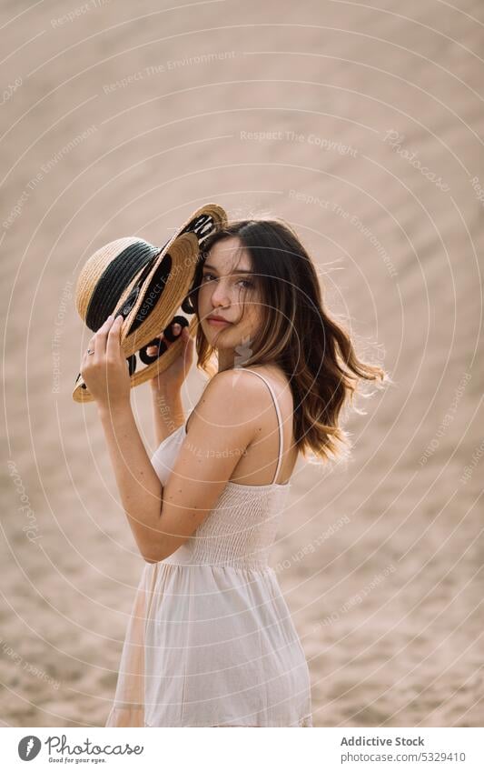 Woman with hat resting on beach woman traveler sand straw hat chill cloudy cover face female model tourism trip journey summer vacation holiday weekend nature