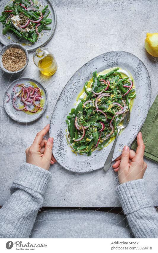 Unrecognizable person with plate of appetizing salad vegetarian onion herb vegetable ingredient food dish fresh portion organic delicious meal lunch vegan tasty