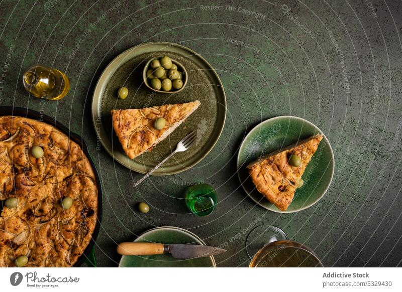 Delicious focaccia bread piece with green olives served on plate fork knife baked food tradition nutrition table oven italian delicious culinary meal cook