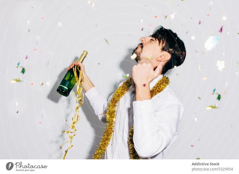 Drunk bearded man with bottle of champagne during Christmas holiday party christmas drunk microphone celebrate confetti portrait festive alcoholic concept