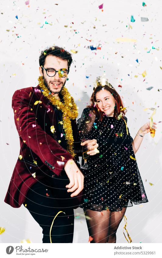 Cheerful friends in stylish wear during New Year party confetti christmas new year alcohol enjoy festive portrait celebrate man woman drink having fun