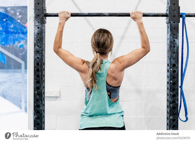 Woman doing pull ups on bar woman gym strong workout sportswoman exercise sportswear athlete healthy training wellness fitness effort wellbeing power strength