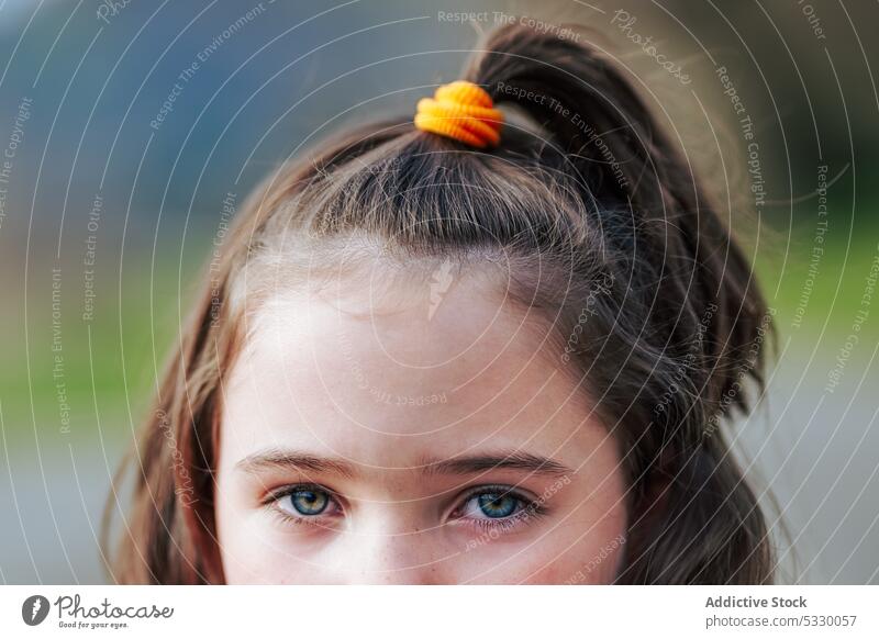 Crop girl child with ponytail hair with yellow hairband kid innocent charming childhood adorable brown eyes gaze cute appearance bright smile little stare