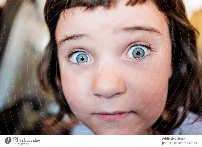 Cute girl looking at camera on blurred background portrait stare make face amazed shock surprise playful funny stun kid reaction headshot childhood cute