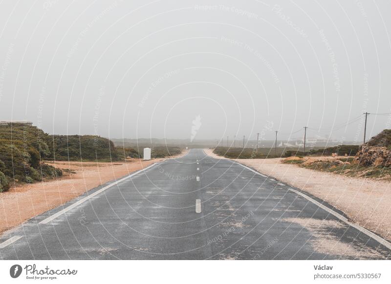 Dusty road to the unknown at the Lighthouse of Cabo de Sao Vicente. The road to Sagres in the Algarve region, Portugal cape cabo de sao vicente point horizon