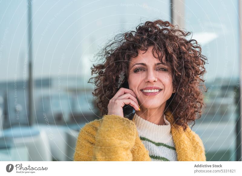 Delighted woman talking on mobile phone on street smartphone call smile positive speak communicate female casual gadget happy city cheerful using conversation