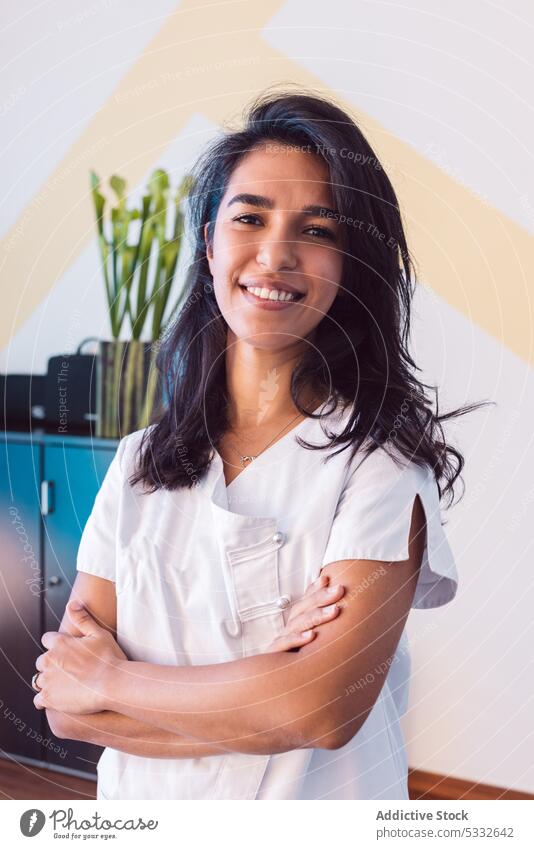 Smiling woman with crossed arms and in scrubs smile professional portrait medic doctor physiotherapist uniform content specialist confident office staff