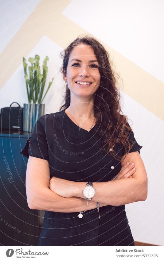 Confident woman with crossed arms looking at camera and smiling doctor smile uniform clinic arms crossed physiotherapist osteopath professional medicine