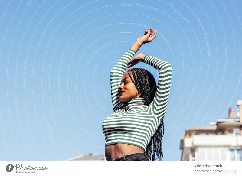 Smiling black woman with arms outstretched happy cheerful street smile enjoy positive glad braid dreadlocks carefree female pleasant ethnic african american