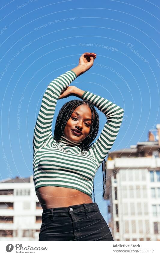 Smiling black woman with arms outstretched happy cheerful street smile enjoy positive glad braid dreadlocks carefree female toothy smile pleasant ethnic