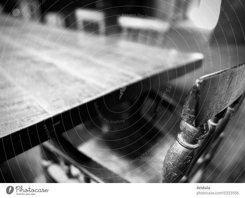 A large wooden dining table with different old wooden chairs b/w Dinner table Dining room Room Furniture Shallow depth of field blurriness Detail Wood Abrasion