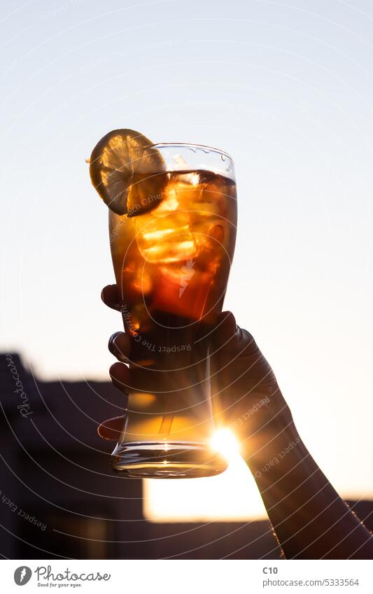 Lady holding a cold glass of Long Island Iced Tea cocktail at sunset Alcohol - Drink Bar - Drink Establishment City Life Cola Cold Drink Cold Temperature