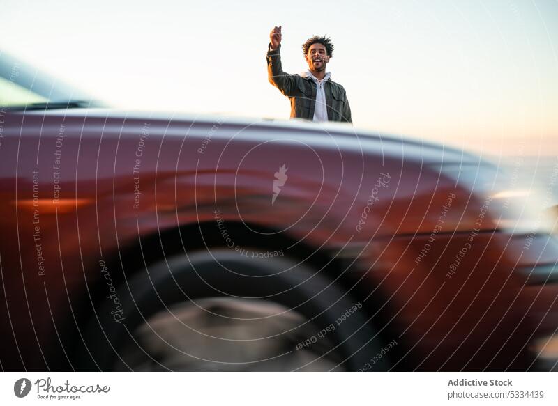 Black man with skateboard hitchhiking on road hitchhike gesture approve street sunset positive skater car drive catch road trip male african american ethnic