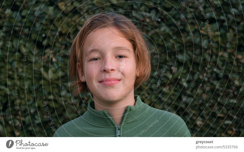 Portrait of a teenager with long hair boy portrait children handsome 12 years old youth man caucasian young confident hairstyle looking at the camera posing