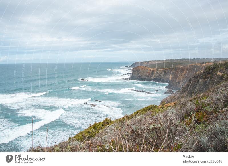 Portugal's western coastline of rocky cliffs and sandy beaches in the Odemira region. Wandering along the Fisherman trail on rainy days point horizon solitude