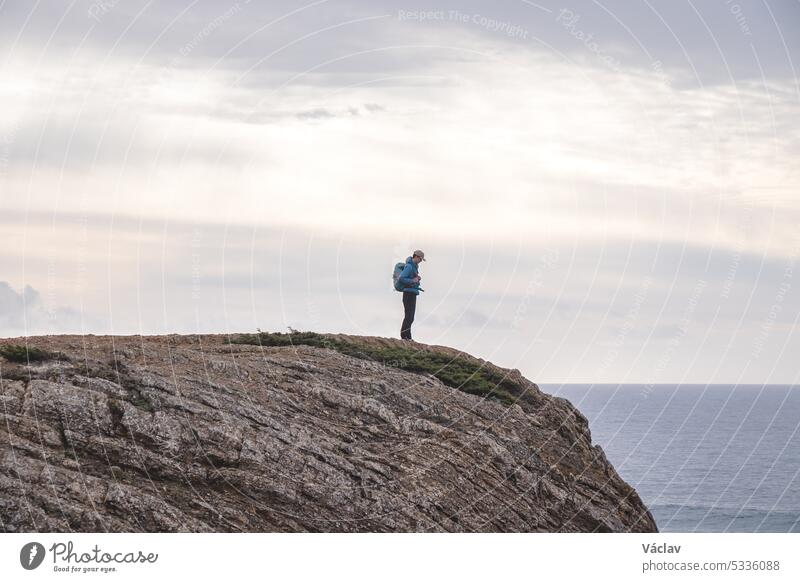 Travel enthusiast enjoys his freedom in the Portuguese countryside on the Atlantic coast observing the endless sea and the shapes of the cliffs. Wandering the Fisherman Trail