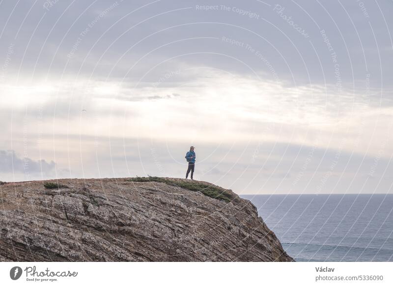 Travel enthusiast enjoys his freedom in the Portuguese countryside on the Atlantic coast observing the endless sea and the shapes of the cliffs. Wandering the Fisherman Trail