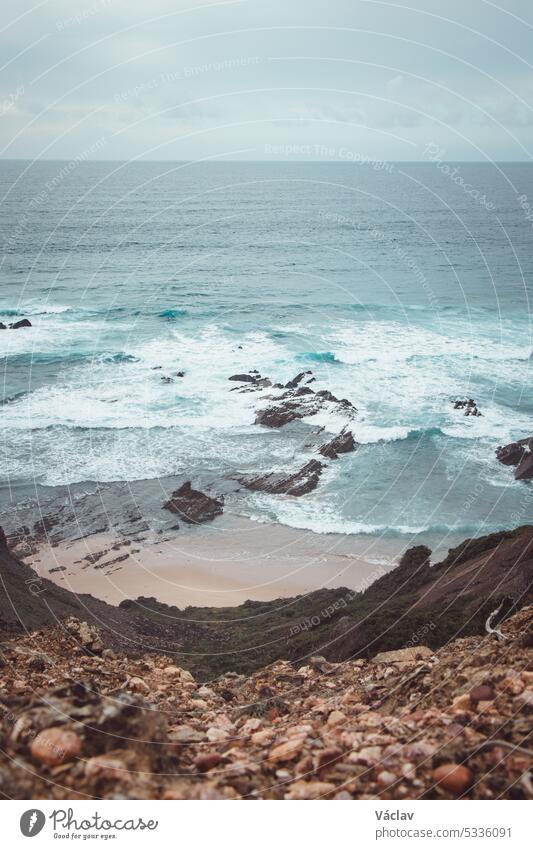 Rocky cliffs with futuristic patterns on the Atlantic coast near the town of Aljezur in southwestern Portugal. The sound of the ocean as the sun sets. Wandering the Rota Vicentina