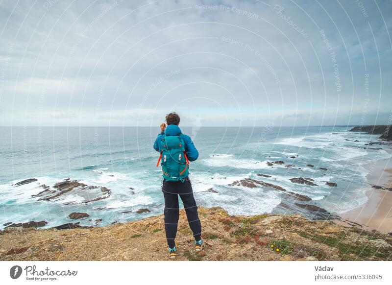 Travel enthusiast enjoys his freedom in the Portuguese countryside on the Atlantic coast observing the endless sea and the shapes of the cliffs. Wandering the Fisherman Trail