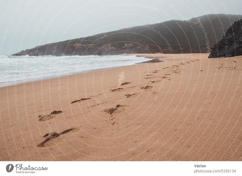 Wandering along the Fisherman Trail in the Algarve region of southwestern Portugal. Human footprints in the sandy surface step imprint human journey seascape