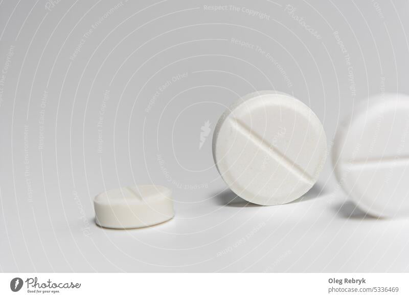 White pills close-up on a light background. drug medicine tablet pharmaceutical closeup medical pharmacy treatment health white vitamin capsule painkiller