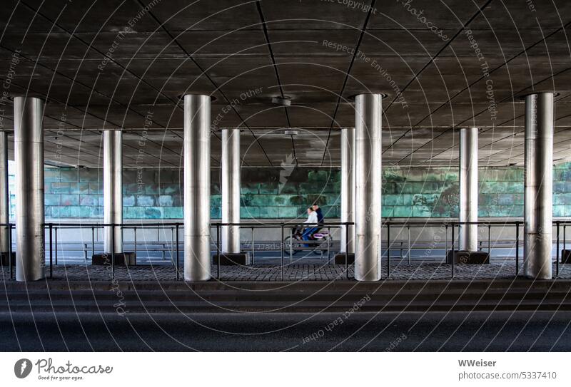 Bicyclists whiz under bridge resting on supporting metal columns Town Bridge Bicycle Driving Speed City props Metal Traffic lane Street Transport Twilight swift