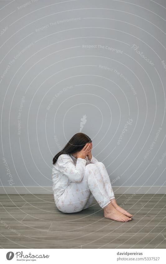 Woman with mental health problems covering her face with hands unrecognizable woman disorder depression desperate anxiety sad sitting floor copy space suffer