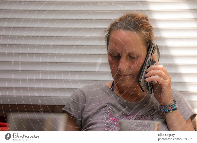 Young feminine woman on phone, looking down Woman portrait Young woman pretty Feminine Exterior shot Shallow depth of field Colour photo Brunette