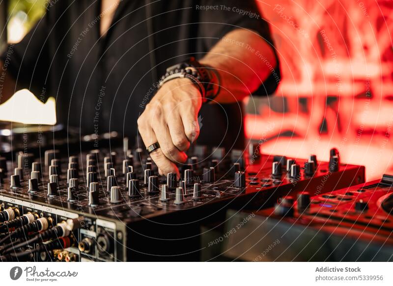 Cropped unrecognizable DJ mixing music on console dj anonymous play festival mixer sound perform audio controller party entertain equipment professional club