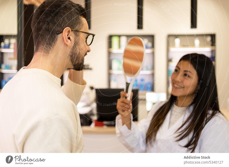 Happy man selecting eyeglasses in shop customer choose smile ophthalmology client choice optical vision eyesight cheerful patient mirror store check doctor