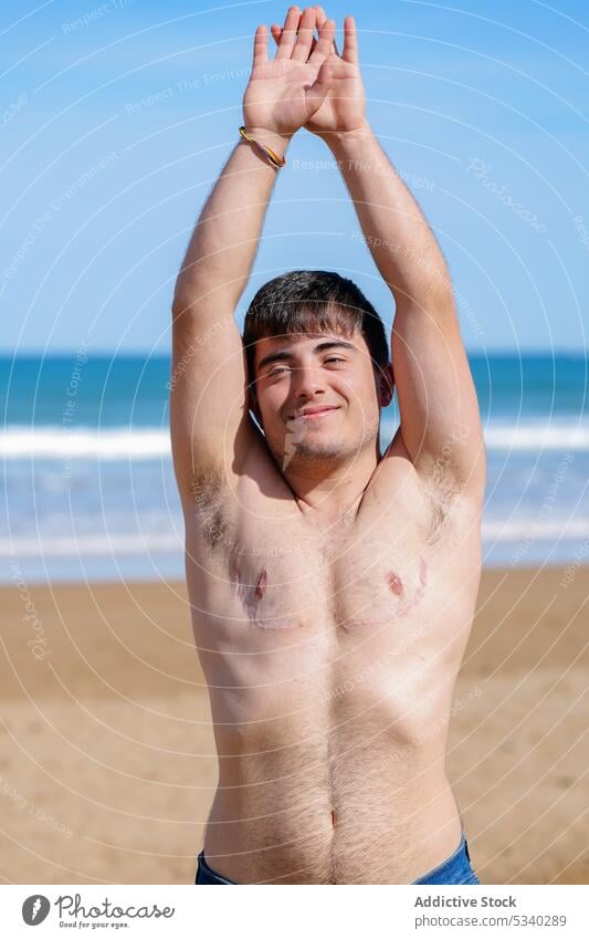 Glad shirtless gay on beach man transgender sunbath sand sea topless smile male lgbt lgbtq homosexual transsexual androgynous queer pride equal rights tolerance