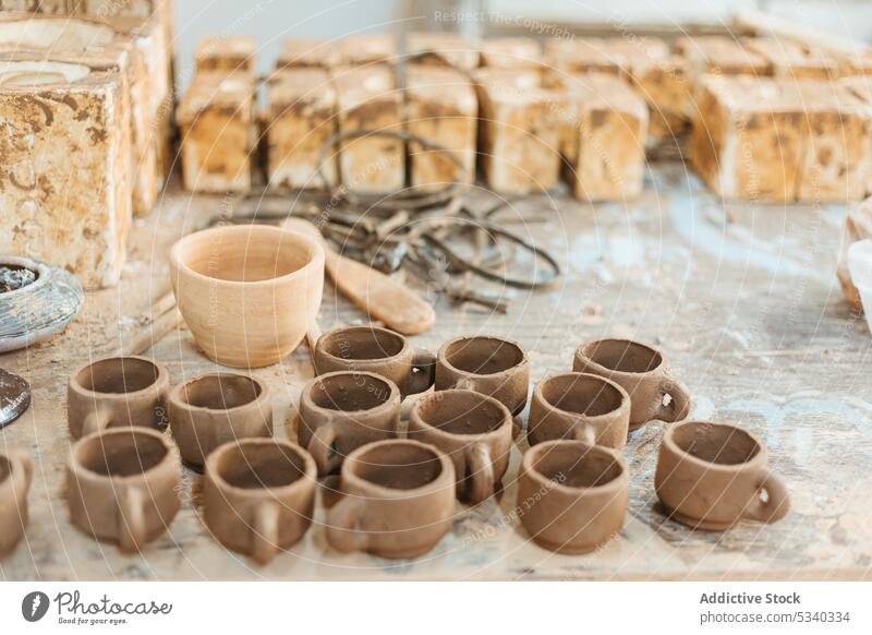 Unfinished clay cups on wooden table vase workshop handmade unfinished creative handicraft professional pottery ceramic collection art shape earthenware set row