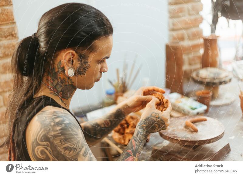 Man creating clay bowl on wheel in workshop man pottery concentrate shape craft skill craftsman artisan ceramic focus creative handmade studio young process