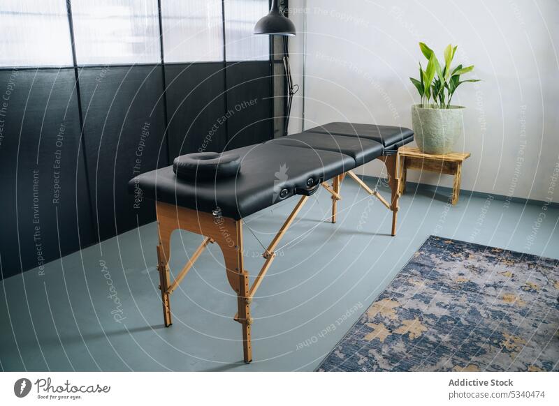 Massage table located near window massage interior therapy furniture room salon headrest comfort medicine spa modern treat healthy cozy care health care