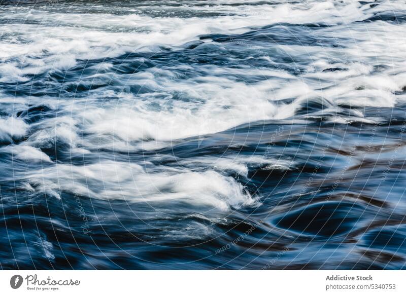 Flowing clear water in motion flow surface ripple blue speed dynamic smooth shine calm slow liquid wavy tranquil clean nature wave splash nobody aqua stream