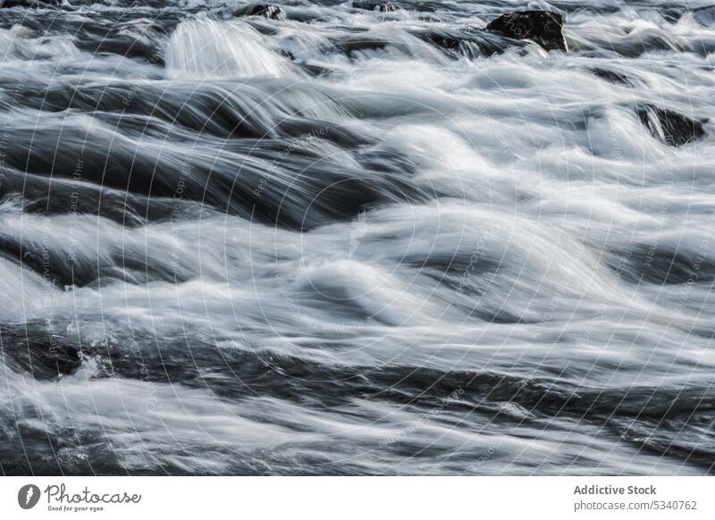 Smooth flow of fast rushing water stream smooth long exposure view blue rapid wild background nature movement waterfall environment ripple river motion cascade