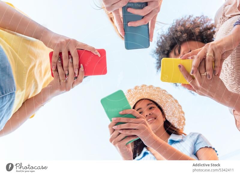 Group of diverse female friends standing with smartphones women using girlfriend friendship circle internet message online connection together browsing