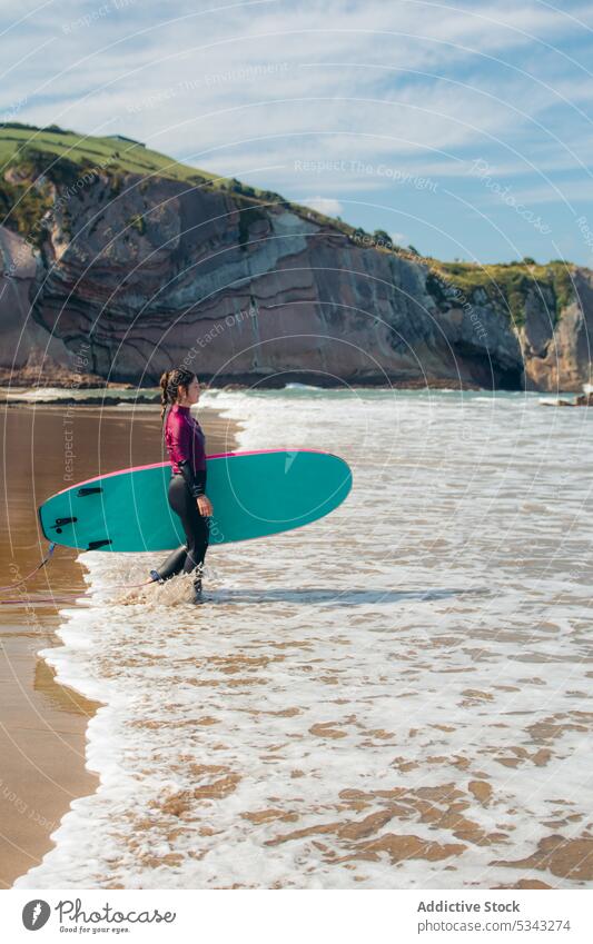 Young woman with surfboard on beach surfer seashore wave activity water holiday sport seaside vacation surfing summer female coast ocean leisure hobby enjoy