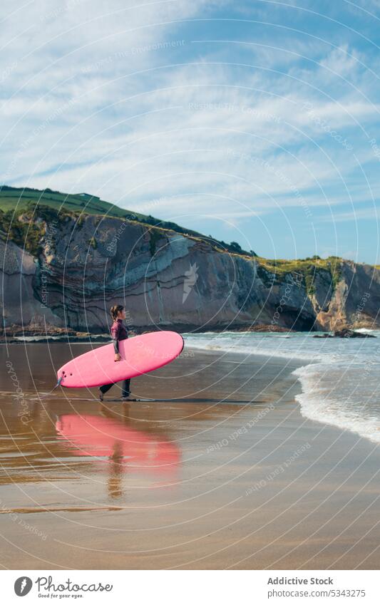 Young woman with surfboard on beach surfer seashore wave activity water holiday sport seaside vacation surfing summer female coast ocean leisure hobby enjoy