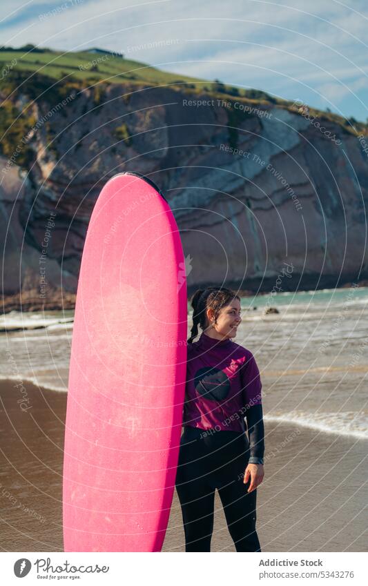 Young woman with surfboard on beach surfer stand seashore wave activity water holiday sport seaside vacation surfing summer female coast ocean leisure hobby